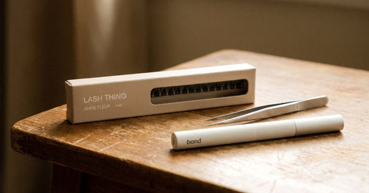 Nep wimpers voor gevoelige ogen: Lashthing cluster lashes met pincet en bond pen op een houten tafel