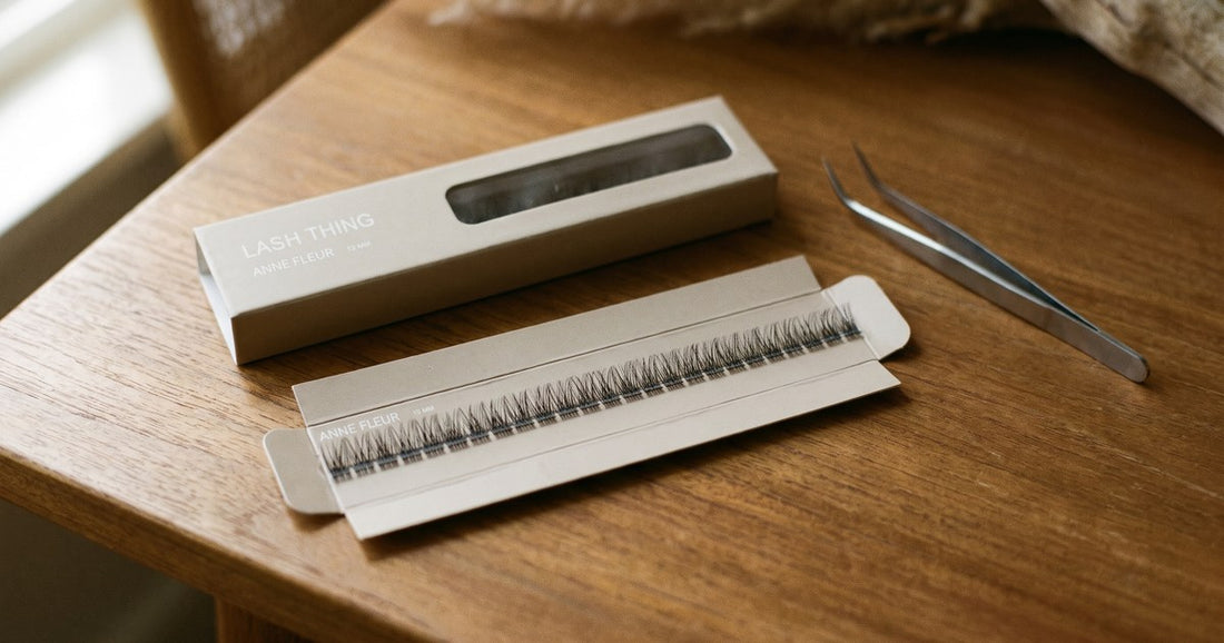 Doosje cluster wimpers met pincet op houten tafel, bij artikel over wimperextensions allergie